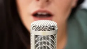A Woman Is Singing Into A Microphone Wallpaper