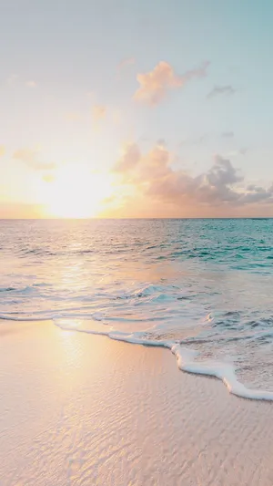 A Woman Is Walking On A Beach At Sunset Wallpaper