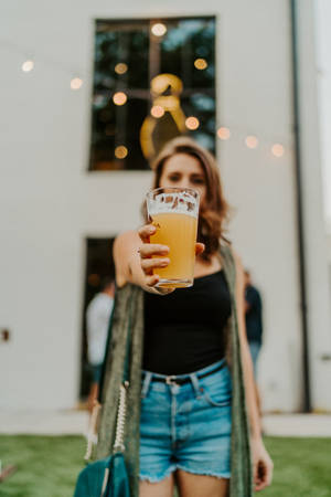 A Woman Raising A Beer In Appreciation Wallpaper