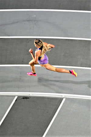 A Woman Running On A Track In A Purple Shirt Wallpaper