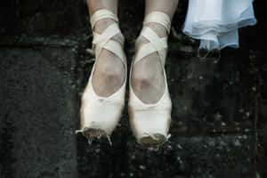 A Woman's Feet Are Hanging From A Wall Wallpaper