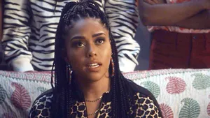 A Woman Sitting On A Couch With Braids Wallpaper