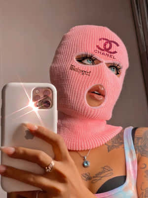 A Woman Wearing A Pink Knitted Mask Taking A Selfie Wallpaper