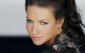 A Woman With Long Hair And Earrings Posing For A Photo Wallpaper