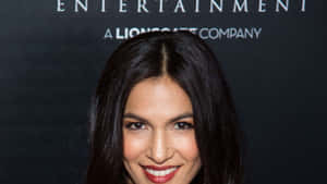 A Woman With Long Hair Smiling At The Red Carpet Wallpaper