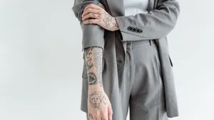 A Woman With Tattoos Wearing A Grey Suit Wallpaper