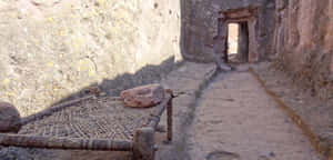 A Wooden Bed Frame Beside Lalibela's Rock-hewn Church Wallpaper