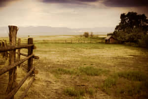 A Wooden Fence In A Field Wallpaper