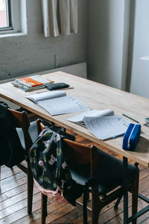 A Wooden Table With A Backpack And A Laptop Wallpaper