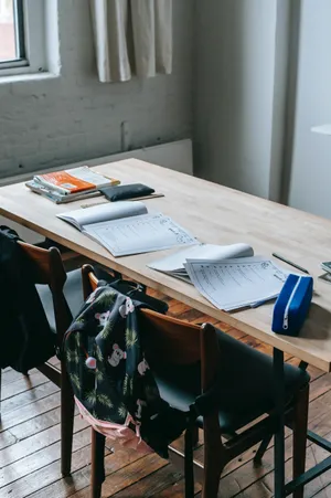 A Wooden Table With A Backpack And A Laptop Wallpaper