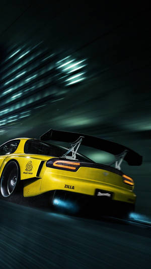 A Yellow Sports Car Driving Down A Dark Street Wallpaper