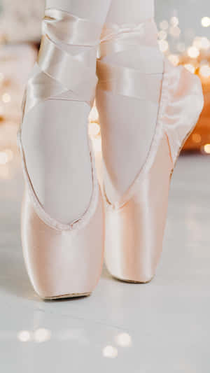 A Young Ballerina Wearing Classic Pointe Shoes Gracefully In A Tutu Wallpaper