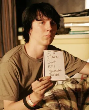 A Young Man Holding A Note In Bed Wallpaper