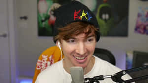 A Young Man Is Smiling While Holding A Microphone Wallpaper