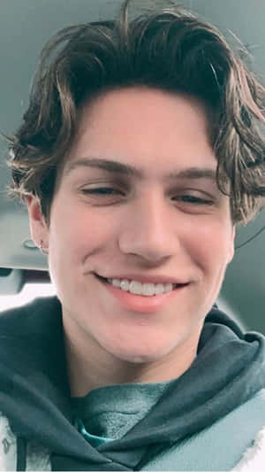 A Young Man Smiling In A Car Wallpaper