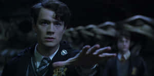 A Young Tom Riddle Wielding A Wand Against A Dark Backdrop Wallpaper
