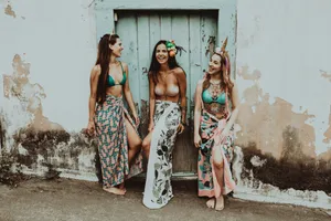 A Young Woman Enjoying Her Stylish Summer Outfit By The Turquoise Sea. Wallpaper