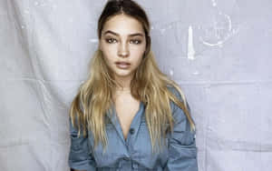 A Young Woman In A Blue Shirt Posing For A Photo Wallpaper