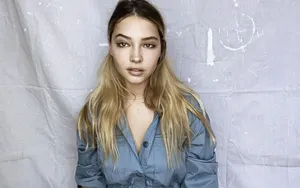 A Young Woman In A Blue Shirt Posing For A Photo Wallpaper
