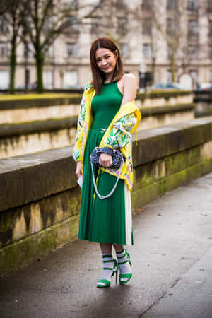 A Young Woman In Nature Wearing Sustainable Green Fashion Wallpaper