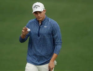 Aaron Wise Holding A Golf Ball Wallpaper