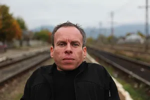 Actor Warwick Davis Posing At An Event Wallpaper