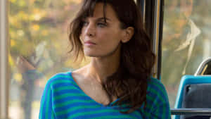 Actress Frankie Shaw Striking A Confident Pose Against A Gray Backdrop Wallpaper