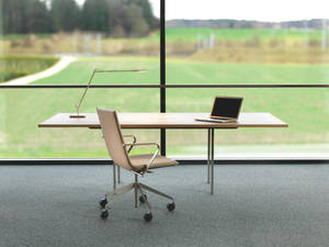 Adjustable Office Desk Set Against A Transparent Glass Wall Wallpaper