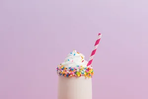 Adorable Assortment Of Colorful Macarons On A Light Pink Surface Wallpaper