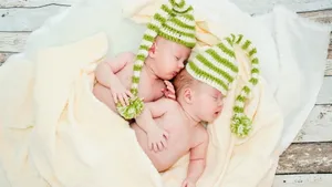 Adorable Baby Smiling In A Flower Field Wallpaper