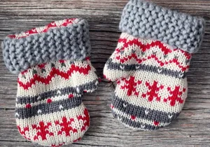 Adorable Mittens Hanging On A Warm Wall Background Wallpaper