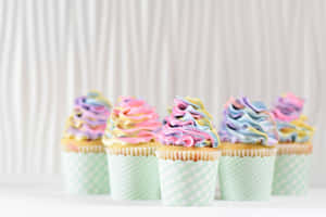 Adorable Pink Frosted Cupcake With Rainbow Sprinkles Wallpaper