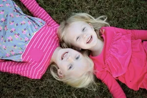 Adorable Toddler Smiling Playfully In A Field Wallpaper