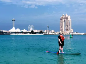 Adventurous Paddleboarder Exploring Serene Lake Wallpaper