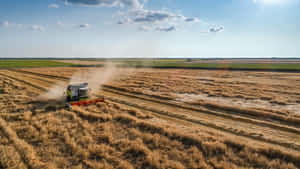 Aerial View Of A Combine Harvester In A Field Wallpaper