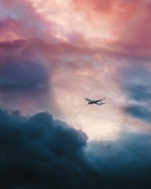 Aerial View Of Airplane Flying Above Pink And Blue Clouds. Wallpaper