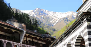 Aerial View Of Rila Monastery Amidst Snow-capped Mountains Wallpaper