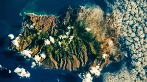 Aerial_ View_of_ Rugged_ Island_ Amidst_ Clouds_4 K Wallpaper