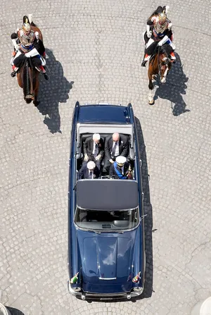 Aerial Viewof Blue Convertible Escortedby Horse Guards Wallpaper