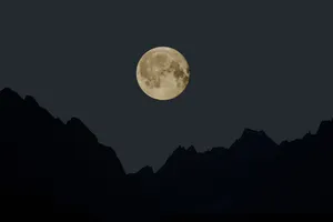 Aesthetic Silhouette Of A Full Moon On A Crisp Night Sky Wallpaper