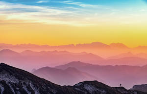 Aesthetic Sky Over Peaks Of Mountains Wallpaper