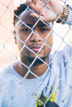 African Man Leaning On Fence Wallpaper