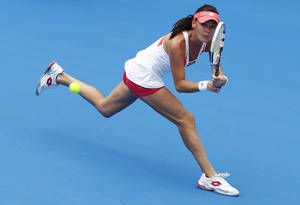 Agnieszka Radwanska Intensely Focused On Hitting A Tennis Ball In A Professional Match. Wallpaper