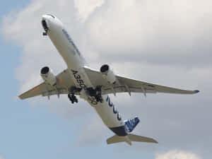 Airbus A350 Ascending Against Cloudy Sky Wallpaper