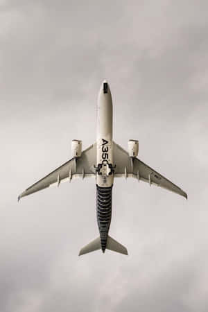 Airbus A350 Ascending Against Cloudy Sky Wallpaper