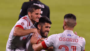 Alejandro Pozuelo And Jonathan Osorio Of Toronto Fc Celebrating On The Field Wallpaper