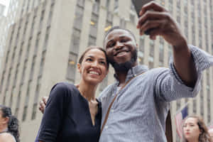 Alexandria Ocasio-cortez Taking Picture With A Man Wallpaper