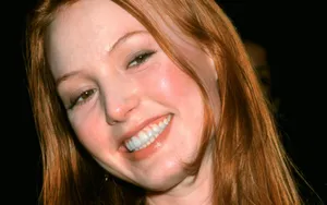 Alicia Witt Smiling Radiantly In Red Dress Wallpaper