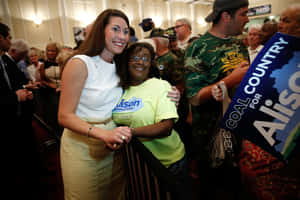 Alison Lundergan Grimes Hugging Woman Wallpaper