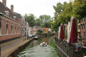 Alkmaar Canal Scenewith Boatand Outdoor Cafe Wallpaper